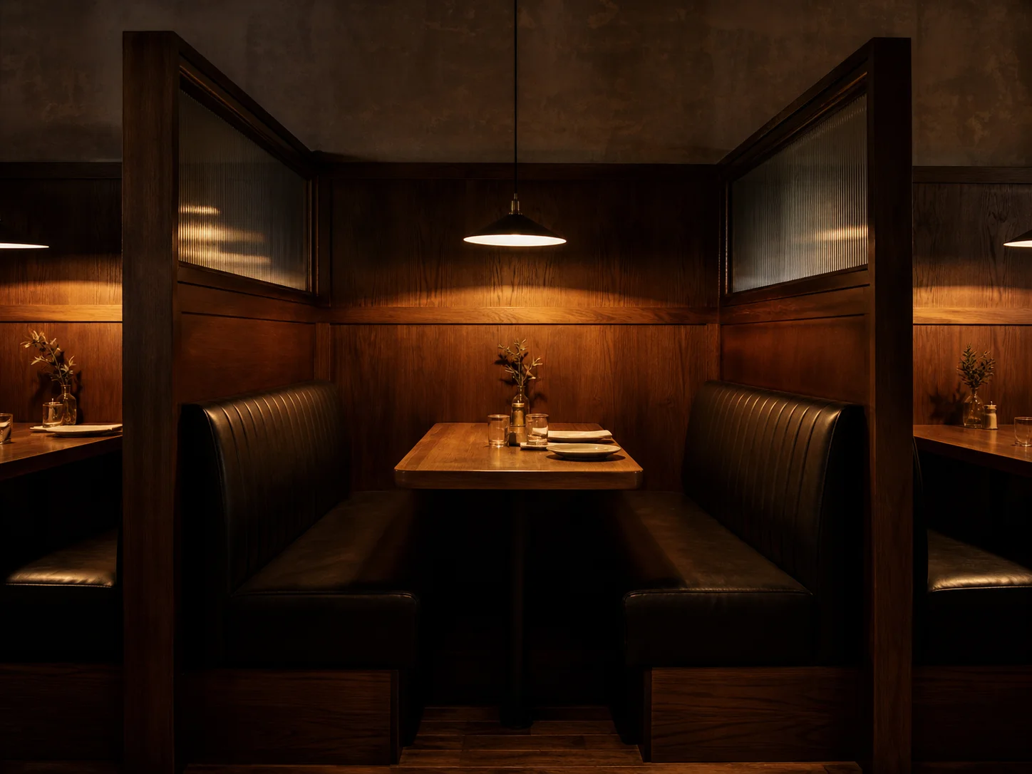 Restaurant-Booth mit hohen Trennwänden zwischen benachbarten Boxen und dunkler Leder-Polsterung